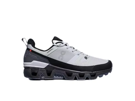A single grey trail running shoe with a black sole, seen from the side