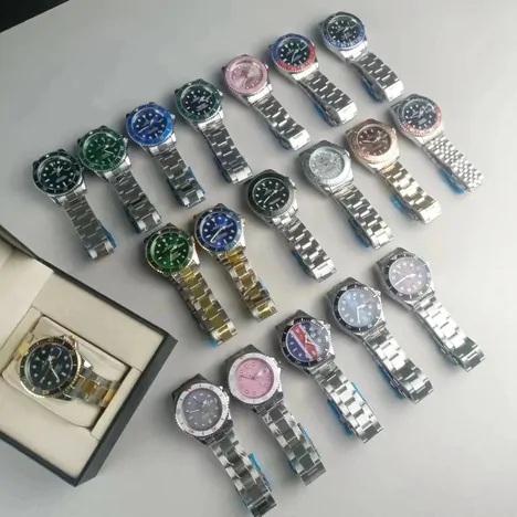 A pile of steel-bracelet wristwatches with green, blue, black and pink dials